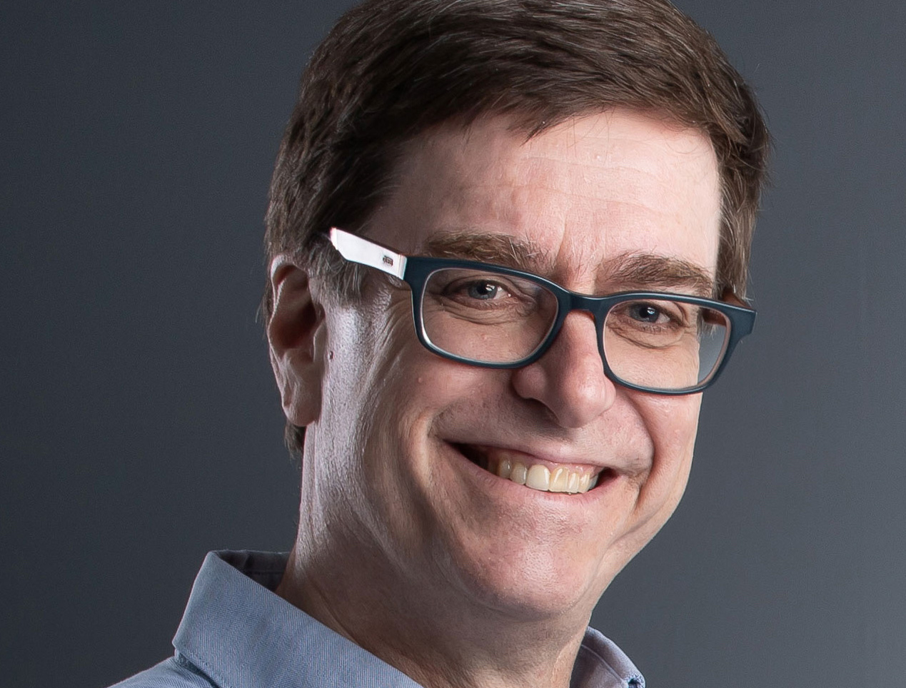 Headshot of Richard Gauder. A smiling man with short brown hair and glasses.